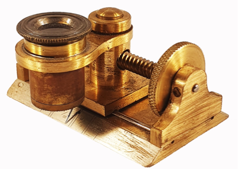 A gold object with a screw
Description automatically generated