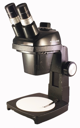 A black microscope with a white cover
Description automatically generated